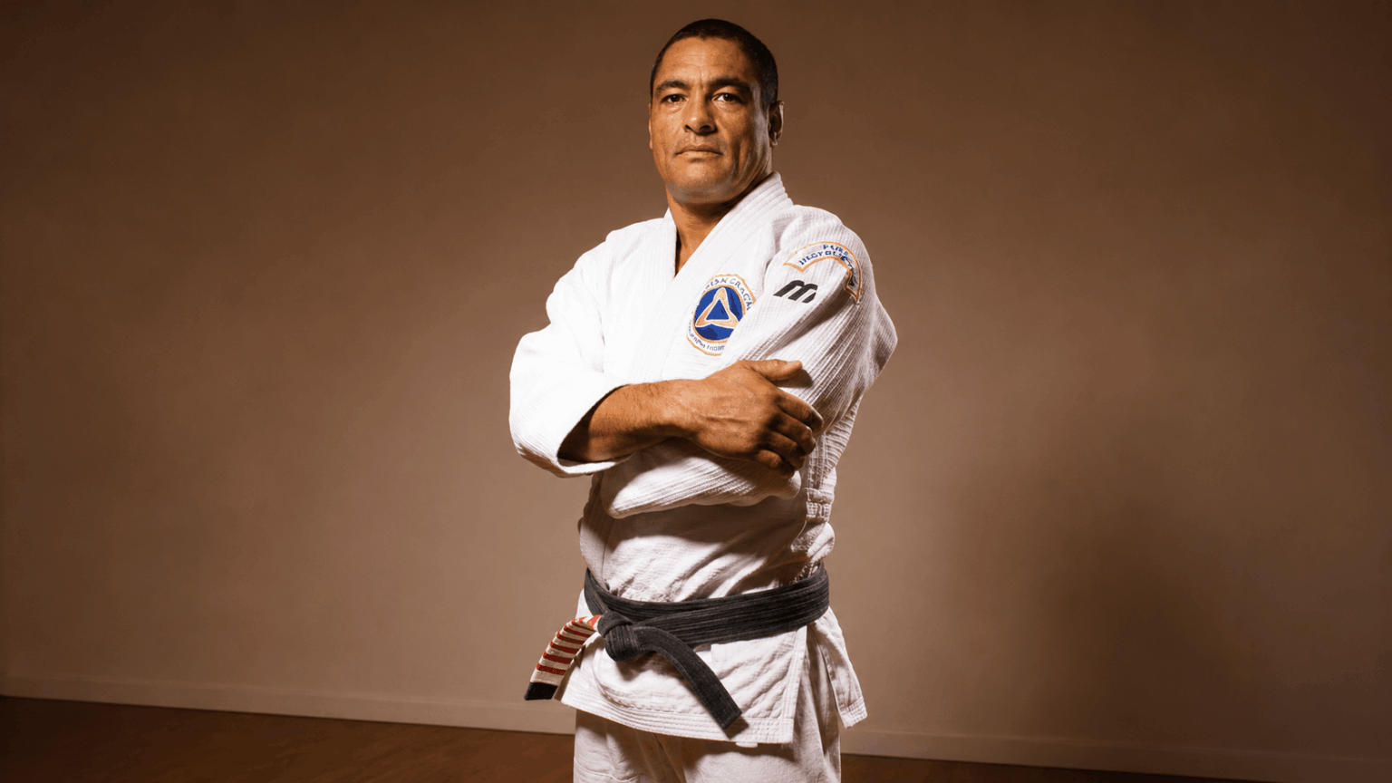 Rickson Gracie Jiu Jitsu: A História Completa do Maior Lutador da Família Rickson Gracie de quimono em pose de mestre lenda do Jiu Jitsu brasileiro
